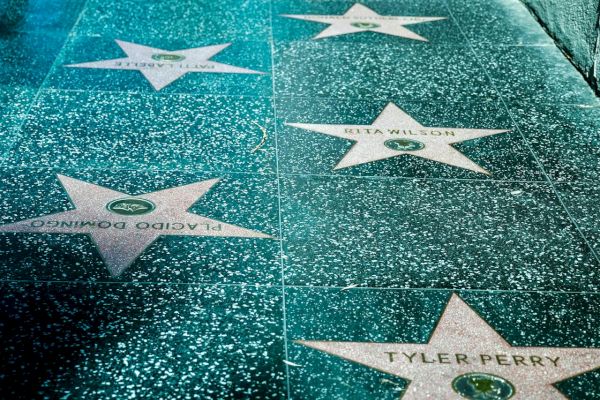 The image shows a section of the Hollywood Walk of Fame, featuring stars embedded in the sidewalk that honor celebrities from the entertainment industry.