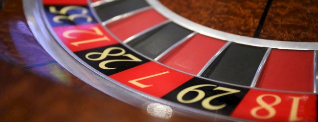 The image shows a part of a roulette wheel with numbered pockets in red, black, and green, commonly found in casinos.