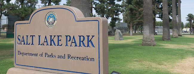 Salt Lake Park sign, with trees and a grassy area in the background, belonging to the Department of Parks and Recreation.