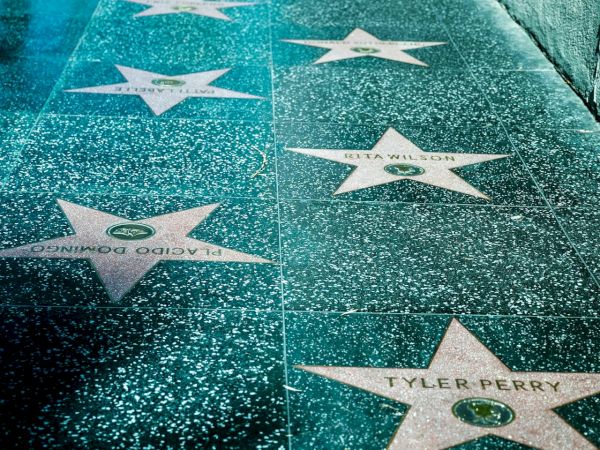 The image shows a section of the Hollywood Walk of Fame, featuring stars embedded in the sidewalk that honor celebrities from the entertainment industry.