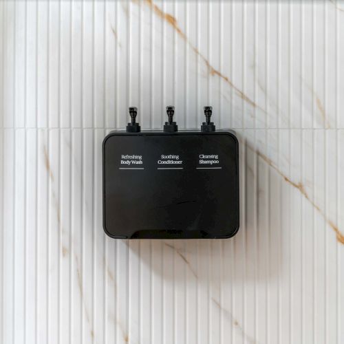 A small black device with three knobs labeled &ldquo;Model,&rdquo; &ldquo;Power/Volume,&rdquo; and &ldquo;Tone/Filter&rdquo; sits on a light marble surface, with three small jacks on top.