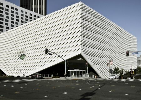 A street-level view of The Broad museum, featuring its sculpted white fa&ccedil;ade of repeating vent-like openings.